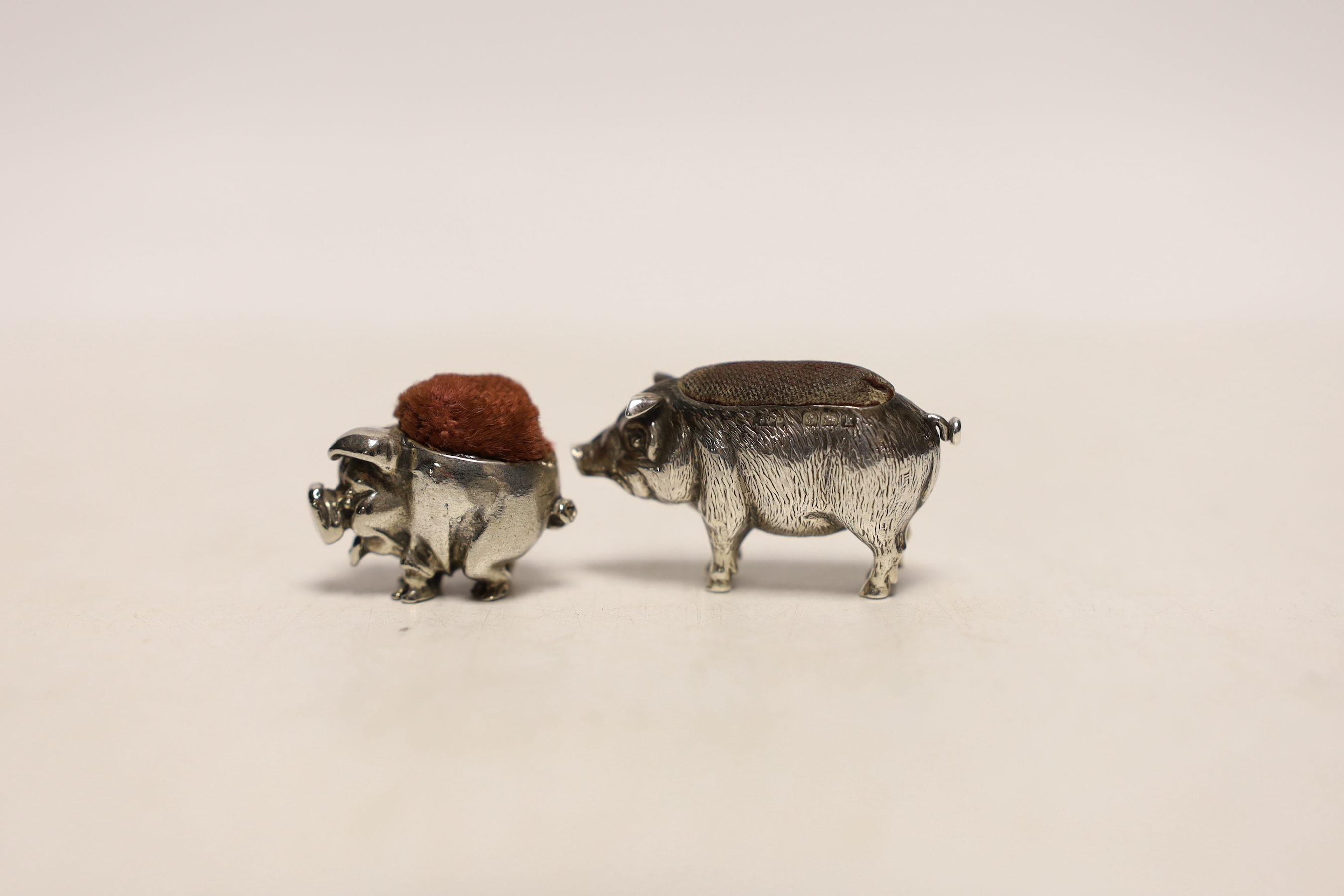 An Edwardian novelty silver pin cushion, modelled as a pig, Adie & Lovekin Ltd, Birmingham, 1909, 39mm and a later metal pig pin cushion.